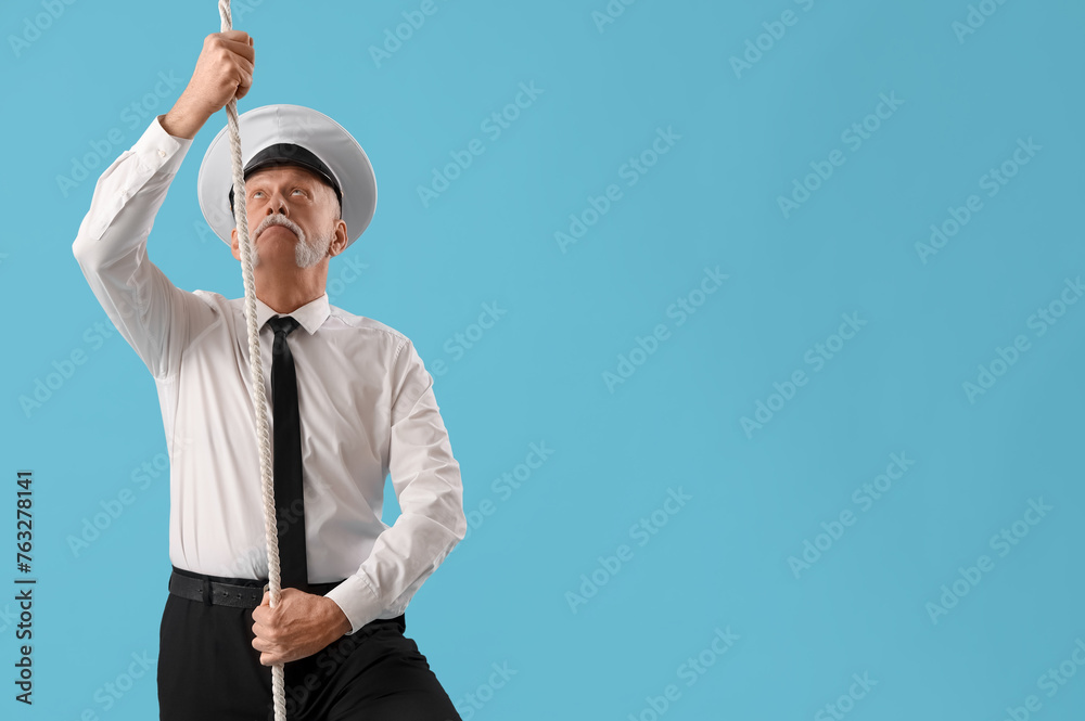 Mature sailor with rope on blue background Mature sailor with rope on blue background