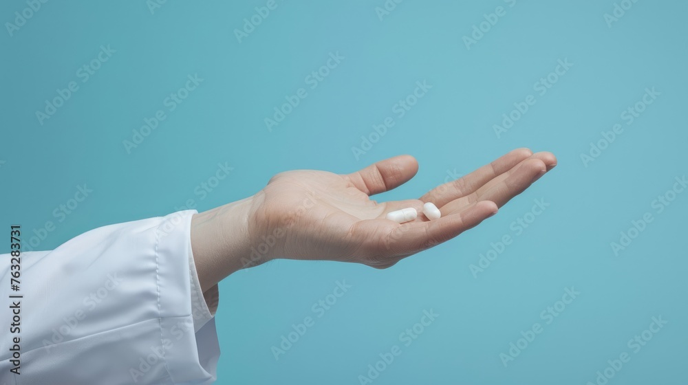 Pills bouncing in person hand with bright blue background Pills bouncing in person hand with bright blue background