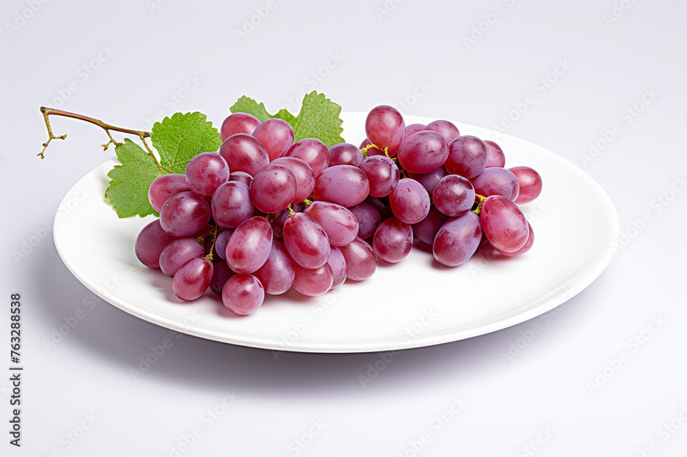 Sweet and ripe red grapes on a plate isolated on white Sweet and ripe red grapes on a plate isolated on white