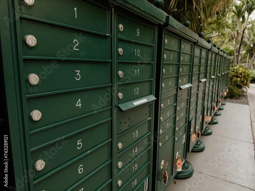A section of residential mailboxes that runs down a parking area.