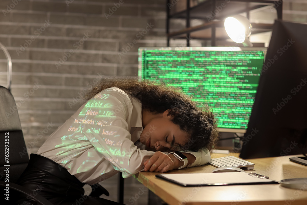 Female African-American programmer sleeping in office at night