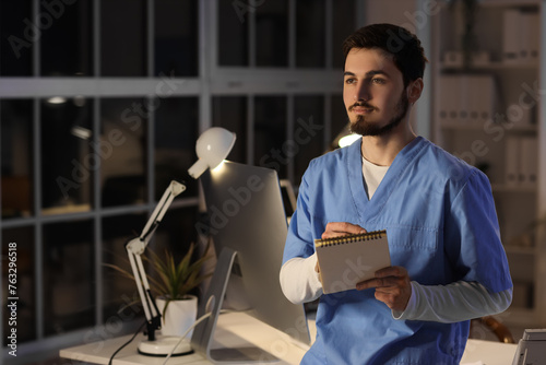 Male nurse writing on noteb...