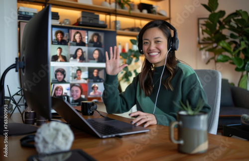Smiling Asian woman in headphones during an online video conference with multiple participants