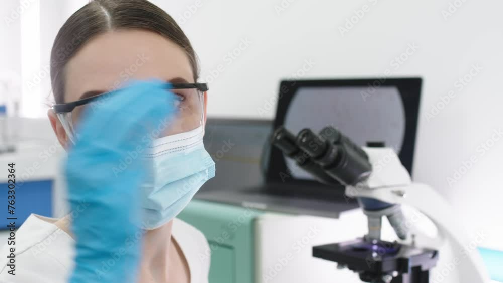 Scientist in a modern medical laboratory looking into a microscope. Microbiologist works on molecular samples in a modern laboratory with technological equipment. Scientist in a modern medical laboratory looking into a microscope. Microbiologist works on molecular samples in a modern laboratory with technological equipment.