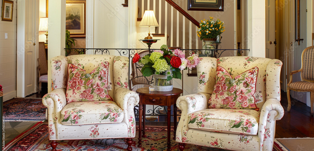 A welcoming lounge of a rural inn with soft sofas and flower elements to create a feeling of charming coziness