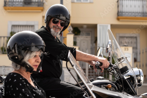 a mature senior couple aged 60 or older prepare for a sidecar ride photo