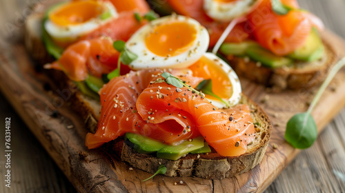 Close-up of healthy breakfast toasts with smoked salmon, avocado, and eggs.