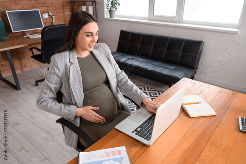 Pregnant businesswoman work...