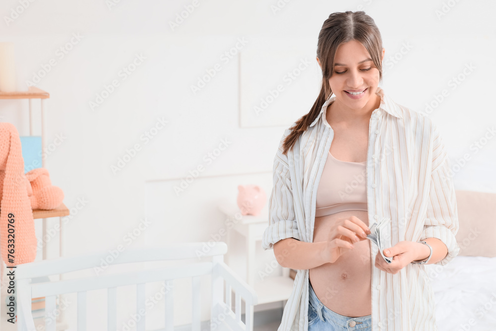 Young pregnant woman with money in bedroom. Maternal Benefit concept Young pregnant woman with money in bedroom. Maternal Benefit concept