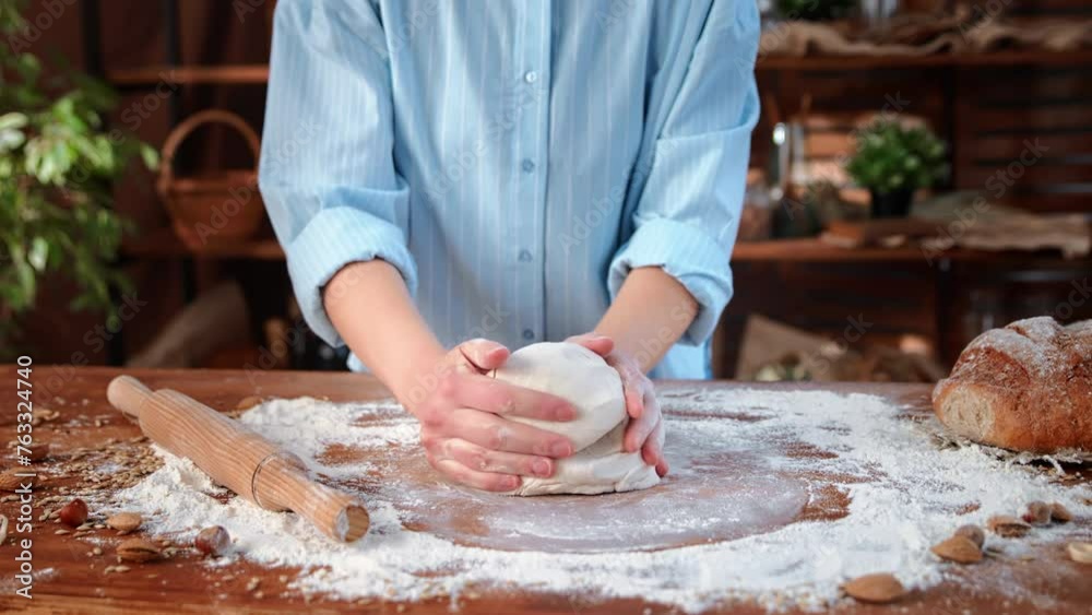 Inside cozy homemade bakery, close-up view of female baker hands kneading dough for bread and loaf Inside cozy homemade bakery, close-up view of female baker hands kneading dough for bread and loaf