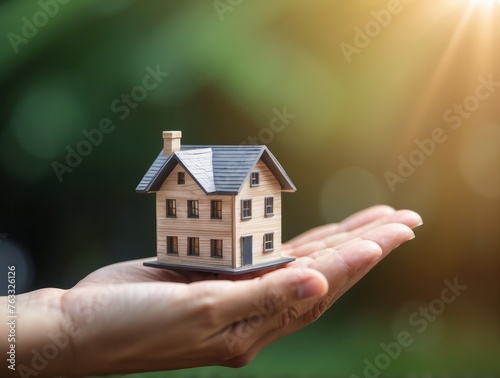 Small house in a human hand, new home, investment and real estate concept