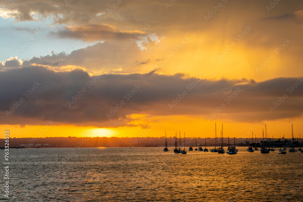 Silhouettes of boats at sunset in San Diego Bay, California