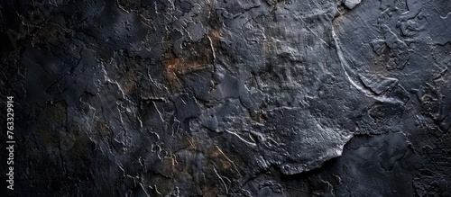 A closeup of a bedrock wall with a dark background, showcasing the textures of the rock and soil. The landscape features an intrusive outcrop with wood accents