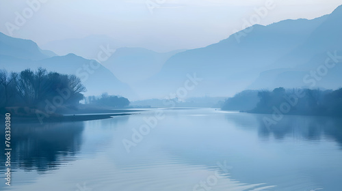 A peaceful river valley bathed in the soft light of dawn, with mountains in the distance © MistoGraphy