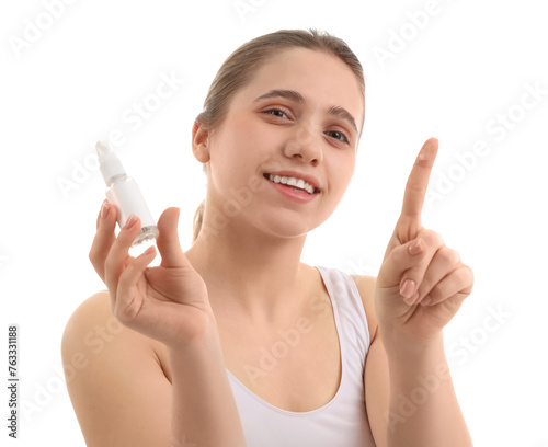 Young woman with bottle of skincare product on white background, closeup