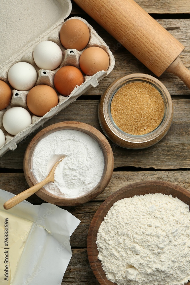 Ingredients for making dough and rolling pin on wooden table, flat lay Ingredients for making dough and rolling pin on wooden table, flat lay