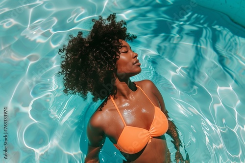 black woman in a bright swimsuit in a turquoise swimming pool