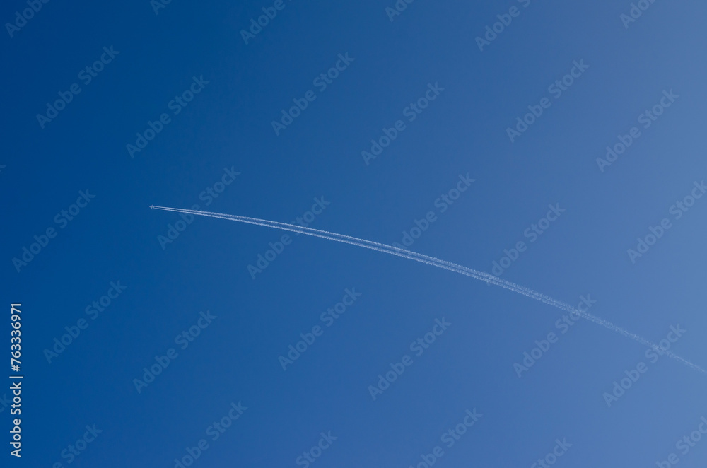 the white trail of the plane in the blue sky the white trail of the plane in the blue sky