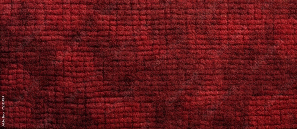 Fototapeta premium A close up of a brown fabric with a checkered plaid pattern in shades of magenta, electric blue, and peach. The fabric is textured like wood in a rectangular shape