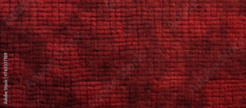 A close up of a brown fabric with a checkered plaid pattern in shades of magenta, electric blue, and peach. The fabric is textured like wood in a rectangular shape photo