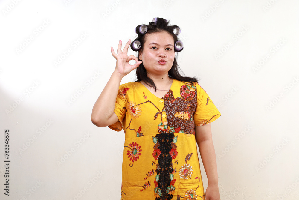 Happy asian housewife standing while showing okay hand gesture or good taste fingers sign Happy asian housewife standing while showing okay hand gesture or good taste fingers sign