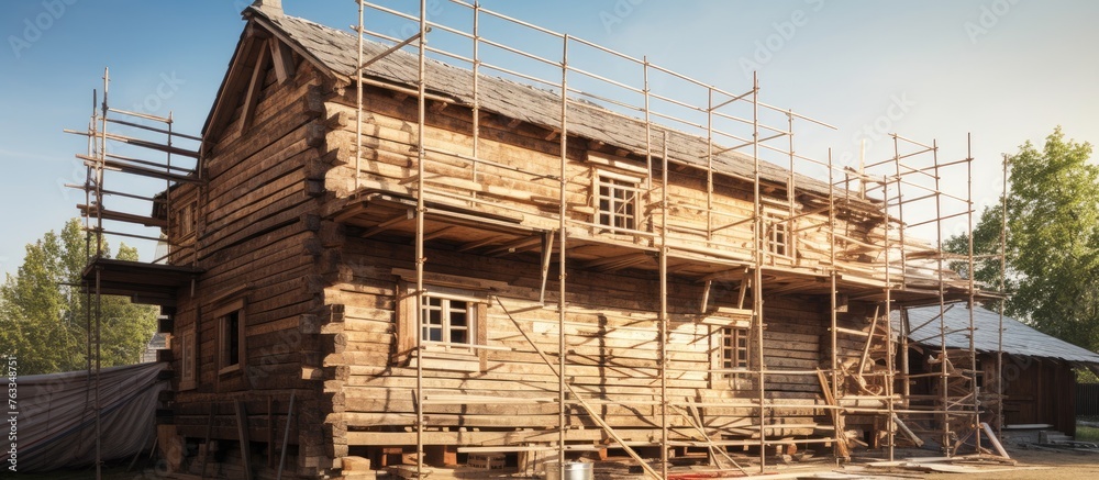 Wooden house construction with scaffolding and roof