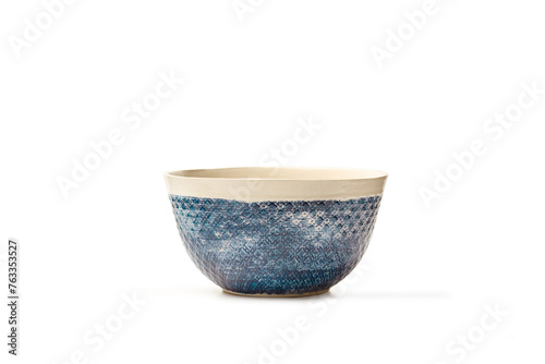 Un cuenco de cerámica con motivos en color azul sobre un fondo blanco aislado. Vista de frente y de cerca. Copy space