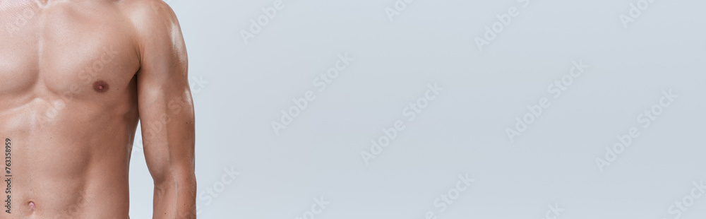 cropped view of sporty man posing topless on gray backdrop and playing his muscles on camera, banner cropped view of sporty man posing topless on gray backdrop and playing his muscles on camera, banner