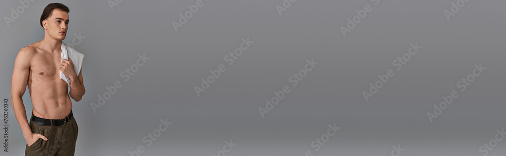 Fototapeta premium alluring young man in brown pants posing topless on gray background and looking away, banner