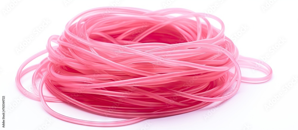 Obraz premium A pink thread close up and a group of hair ponytail rubber bands on white surface