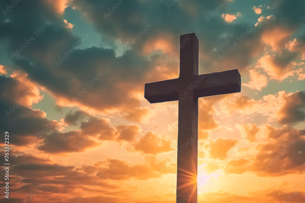 A large cross is standing in front of a cloudy sky. The sky is orange and the sun is shining brightly A large cross is standing in front of a cloudy sky. The sky is orange and the sun is shining brightly