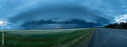 Panorama of supercell thunderstorm clouds over farmland and a country road; Grande Prairie, Alberta, Canada photo