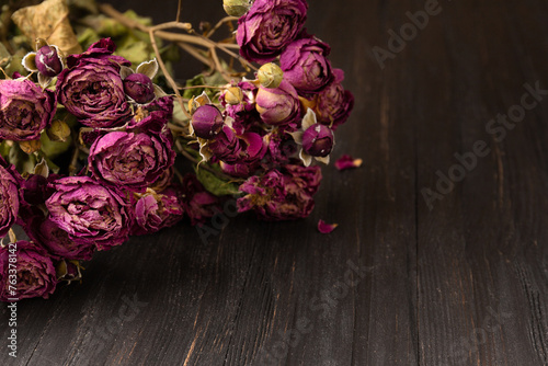 Bouquet of dry roses close-up on a wooden background.