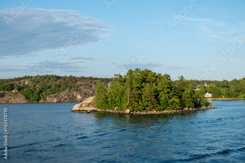 Archipelago Stockholm Sweden. Islet with lush nature in Baltic rippled sea. View from cruise boat.