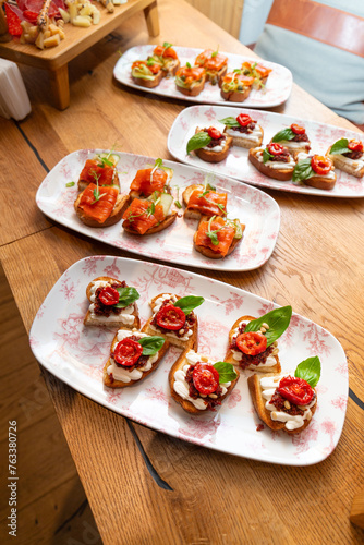 Assorted bruschetta with salmon, sun-dried tomatoes in plates on a table in a restaurant