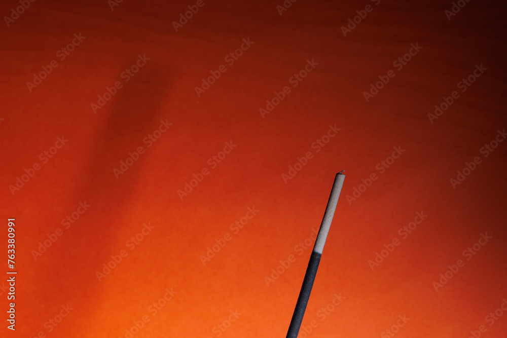 Fototapeta premium A fume and its shadow on the orange background