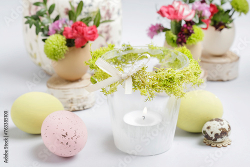 Florist at work: woman shows how to make simple Easter candle holder using a random glass and moss. Step by step, tutorial.
