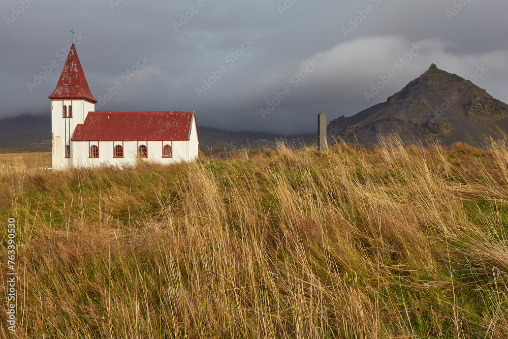Church in the countryside of western Iceland with grass fields and rocky landforms; Hellnar, Snaefellsnes, Iceland Church in the countryside of western Iceland with grass fields and rocky landforms; Hellnar, Snaefellsnes, Iceland