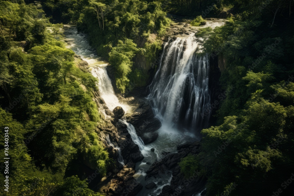Aerial perspective of a picturesque waterfall hidden in a dense forest