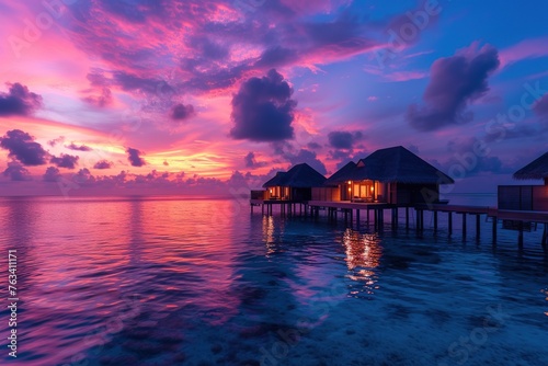 Amazing sunset panorama at Maldives. Luxury resort villas seascape with soft led lights under colorful sky. Beautiful twilight sky and colorful clouds. Beautiful beach background for vacation holiday © interior