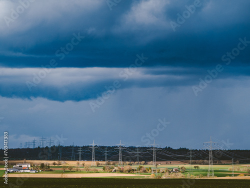 Strommasten einer   berlandleitung und dunkler Wolkenhimmel