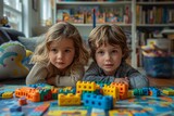 Siblings lying down focused on playing with colorful building blocks
