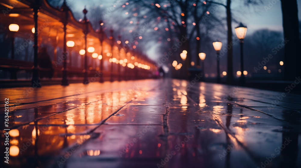 Rainy evening on city street with glowing lamps. Urban autumn and weather concept.