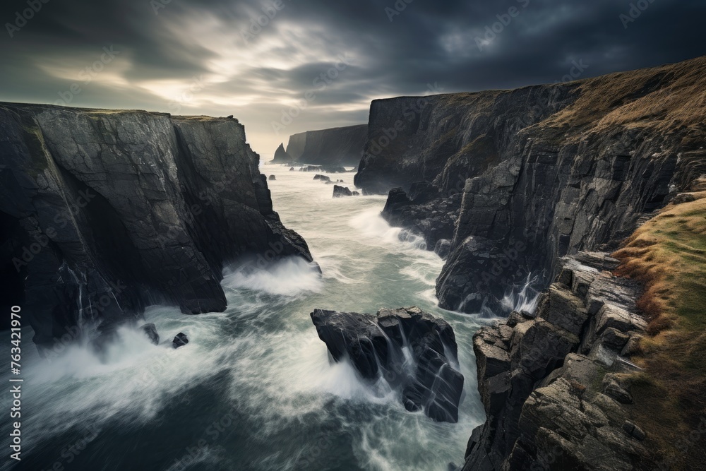 Coastal cliffs with crashing waves under a moody sky Coastal cliffs with crashing waves under a moody sky