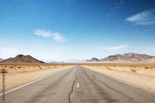 An empty road cutting through a stark, arid desert landscape