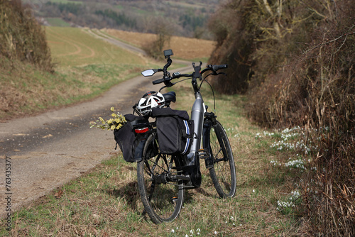 Spring. Bicycle standing by the road with willow in bag
