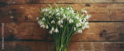 A collection of white flowers arranged neatly in a bouquet, placed atop a wooden table