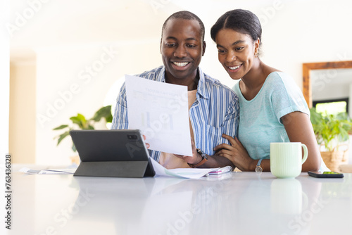 A young African American couple is reviewing finances at home photo