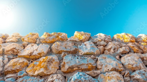 A vast accumulation of rocks stacked beneath a clear blue sky photo