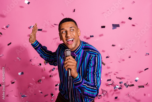 Photo of funky good mood guy wear striped shirt having fun singing microphone isolated pink color background photo